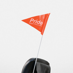 Orange triangular Pride Mobility safety flag on a white pole behind a mobility seat