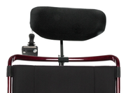 Black headrest and attendant joystick control mounted behind a red wheelchair backrest